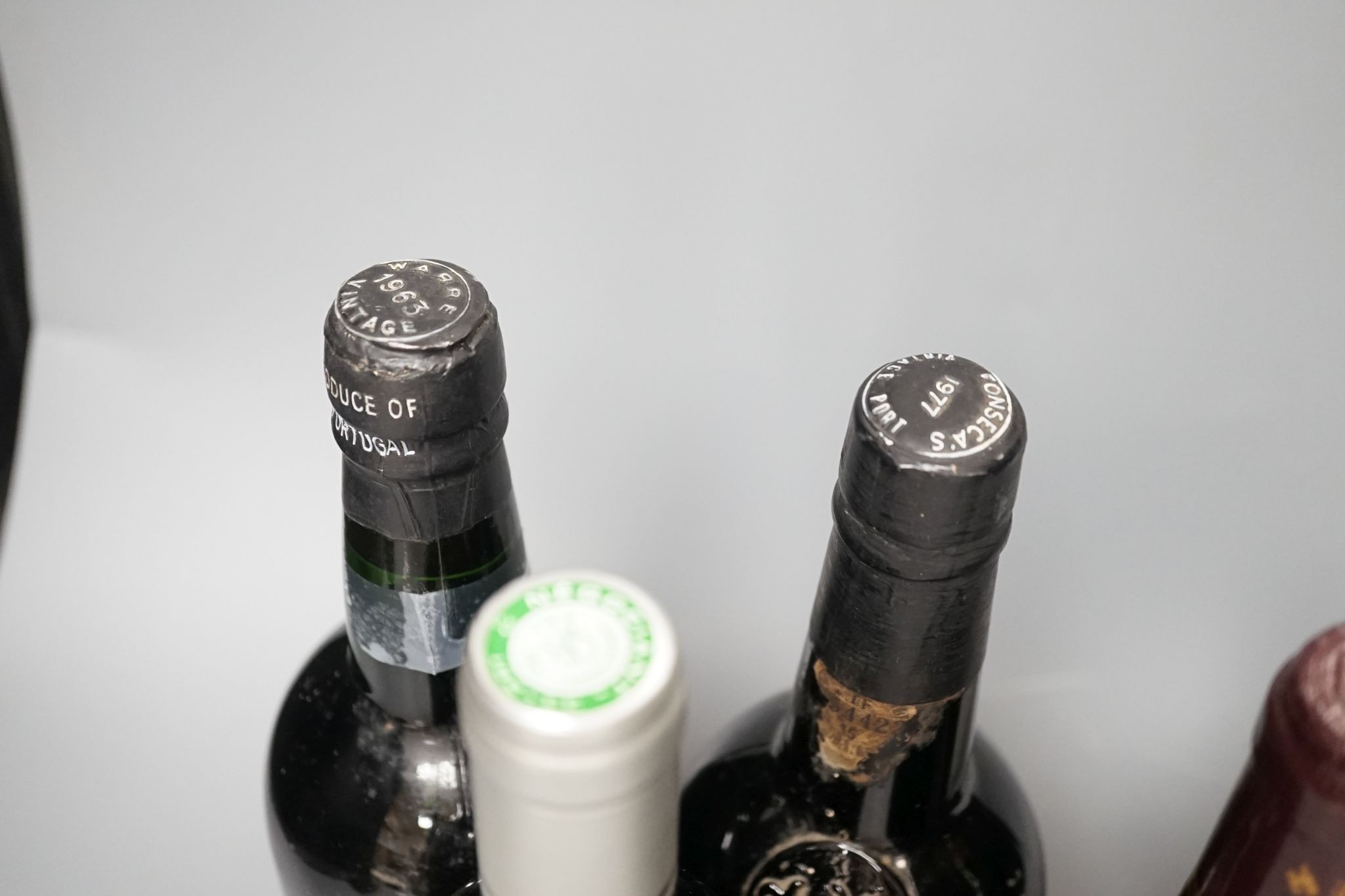 A bottle of Warres 1963 Vintage Port, a bottle of Fonsecca, 1977 Vintage Port and three bottles of wine